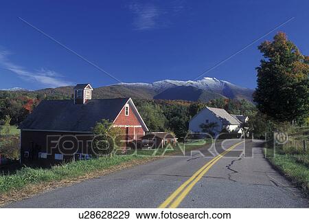 Stock Photo -  mountain, snow, farm, Cambridge, VT, Vermont, Mt. Mansfield, Scenic view of the first snow on Mount Mansfield in the fall from a country road winding along next to a red barn in Cambridge from Pleasant Valley. Fotosearch