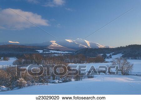 Stock Image -  mountain, winter scene, snow, Mt. Mansfield, Scenic view of the snow covered Mount Mansfield and the picturesque countryside of Cambridge at sunset in winter in Lamoille County in the state of Vermont. . Fotosearch