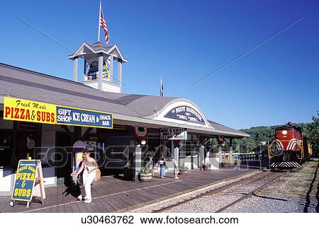 Stock Image -  New Hampshire, train station, Weirs Beach, NH, Winnipesaukee Railroad train pulls up to Weirs Station on Lake Winnipesaukee at Weirs Beach.. Fotosearch