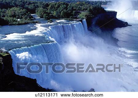Stock Image -  Niagara Falls, NY, waterfalls, New York, American Falls with Canadian Falls (Horseshoe Falls) in the background at Niagara Falls. . Fotosearch