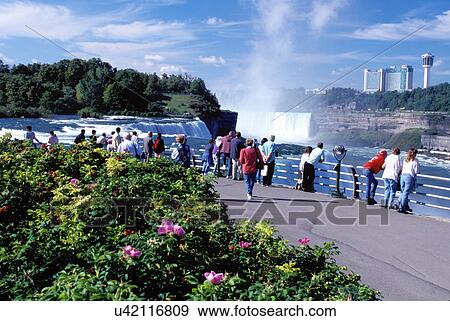 Stock Photo -  Niagara Falls, NY, waterfalls, New York, People at Prospect Park overlook looking at Niagara Falls. American Falls and Canadian Falls (Horseshoe Falls) . Fotosearch