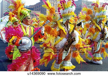 Stock Image -  parade, costume, band, Philadelphia, PA, Pennsylvania, Members of a String Band dressed in fancy colorful costumes with feathers play their instruments and strut in the Mummers Day Parade on New Years Day in Philadelphia.. Fotosearch