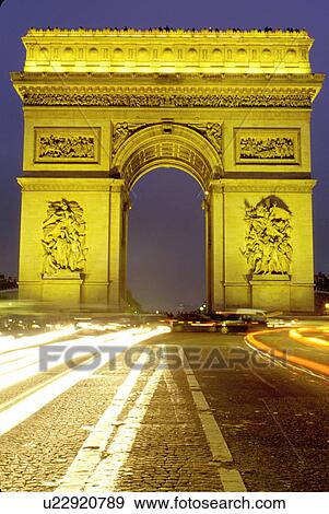 Stock Photo -  Paris, Arc de Triomphe, France, Europe, Arc de Triomphe at Place Charles de Gaulle illuminated at night in Paris. Headlights of traffic passing around the base of the arc.. Fotosearch