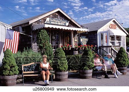 Perkins Cove, Ogunquit, Maine, ME, People relax on the benches in front of shops in the scenic fishing village of Perkins Cove.  View Large Photo Image Stock Photo -  Perkins Cove, Ogunquit, Maine, ME, People relax on the benches in front of shops in the scenic fishing village of Perkins Cove. . Fotosearch