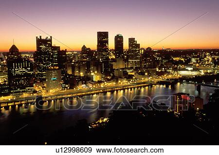Stock Photo -  Pittsburgh, PA, skyline, Pennsylvania, Aerial view of the downtown skyline of Pittsburgh illuminated at sunrise along the Monongahela River.. Fotosearch