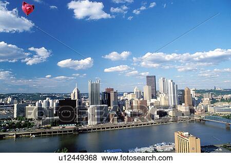 Stock Photo -  Pittsburgh, skyline, hot-air balloon, PA, aerial, Pennsylvania, Downtown skyline of Pittsburgh and pink pig hot-air balloon from the Three Rivers Regatta Festival along the Monongahela River.. Fotosearch