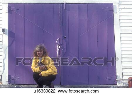 purple, barn door, Woman wearing a yellow jacket squatting in front of a purple barn door holds a kitten in her arms in Peacham in Caledonia County in the state of Vermont View Large Photo Image Stock Image - purple, barn door, Woman wearing a yellow jacket squatting in front of a purple barn door holds a kitten in her arms in Peacham in Caledonia County in the state of Vermont . Fotosearch