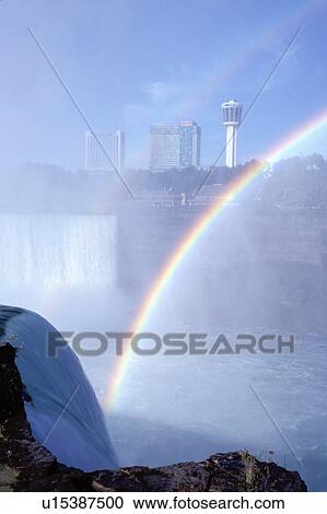 Stock Image -  rainbow, Niagara Falls, NY, waterfalls, New York, Rainbow over American Falls and Horseshoe Falls on the Canadian side. . Fotosearch