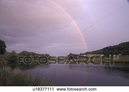Stock Image -  rainbow, Vermont, VT, Rainbow after a thunderstorm over a farm along the Winooski River in Middlesex.. Fotosearch
