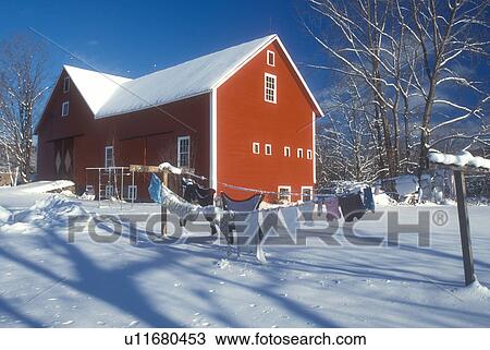 Stock Image -  red barn, clothesline, laundry, winter scene, Vermont, A red barn and clothes drying on a line in the snow under a clear blue sky in winter in Underhill in Chittenden County in the state of Vermont. . Fotosearch
