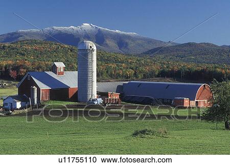 Stock Image -  red barn, mountain, snow, Fletcher, VT, Vermont, Mt. Mansfield, Scenic view of the first snow on Mount Mansfield in the fall from Tinker Farm in Fletcher.. Fotosearch