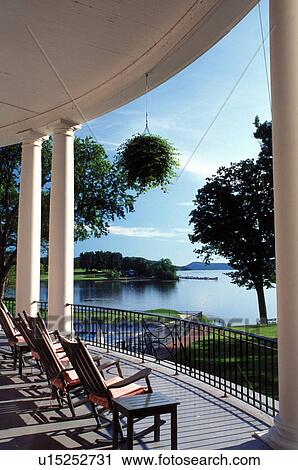 Stock Image -  resort, rocking chairs, Cooperstown, New York, Rocking chairs on the porch of The Otesaga Resort Hotel and golf course in Cooperstown, NY.. Fotosearch