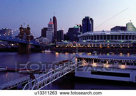 Stock Image -  riverboat, Cincinnati, OH, Ohio, downtown skyline, Mike Fink Restaurant, a stern-wheeler riverboat on Riverboat Row, along the Ohio River. Downtown skyline and Cinergy Field across the Ohio River.. Fotosearch