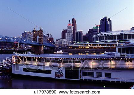 Stock Image -  riverboat, Cincinnati, OH, Ohio, downtown skyline, Mike Fink Restaurant, a stern-wheeler riverboat on Riverboat Row, along the Ohio River. Downtown skyline and Cinergy Field across the Ohio River.. Fotosearch