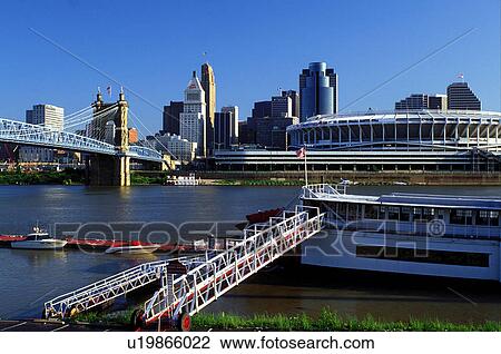 Stock Image -  riverboat, Cincinnati, OH, Ohio, downtown skyline, Mike Fink Restaurant, a stern-wheeler riverboat on Riverboat Row, along the Ohio River. Downtown skyline and Cinergy Field across the Ohio River.. Fotosearch