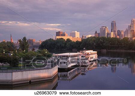 Stock Photo -  riverboat, skyline, Minnesota, Minneapolis, MN, Twin Cities, Riverboats at Boom Island Park along the Mississippi River. Downtown skyline in the background.. Fotosearch
