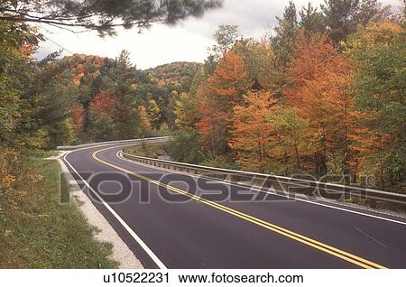 Stock Image -  road, fall, Northfield, VT, Vermont, Route 12A winds through forest in autumn in Northfield.. Fotosearch