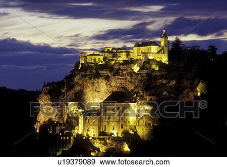 Stock Photo -  Rocamadour, Perigord, Dordogne, France, Lot, Midi-Pyrenees, Europe, The fortified pilgrimage town of Rocamadour situated on the terraced limestone cliffs is illuminated at night. . Fotosearch
