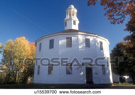 Stock Image -  round church, autumn, Vermont, Colorful fall foliage surround The Old Round Church National Historic Landmark in the fall in Richmond in Chittenden County in the state of Vermont. The Round Church is 16-sided polygon that appears round.. Fotosearch