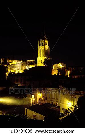 Stock Image -  Saint Emilion, Aquitaine, Europe, Bordeaux Wine Region, Gironde, France, The medieval village of St. Emilion and Eglise Monolithe illuminated at night.. Fotosearch