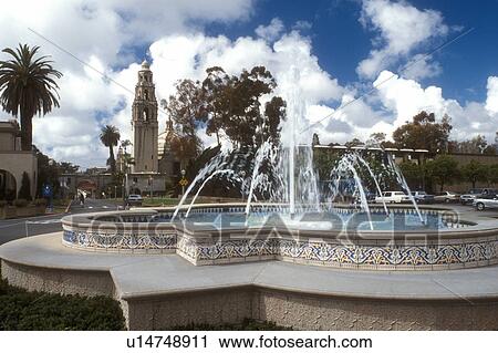 Stock Image -  San Diego, California, CA, Fountain at Plaza de Panama and view of California Tower at Balboa Park in San Diego.. Fotosearch