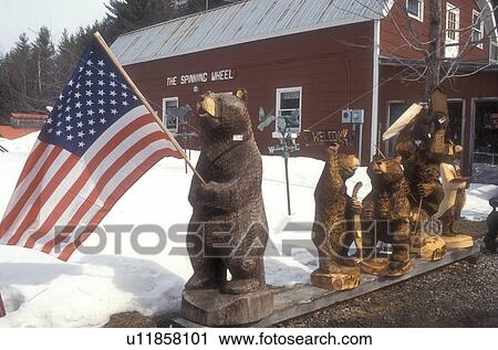 sculpture, bear, flag, wood carving, Stowe, Wooden bear figures carved from a chainsaw displayed outside the Spinning Wheel Gift Shop in Stowe in Lamoille County in the state of Vermont. The large bear in front holds the U. S. flag. View Large Photo Image Stock Image - sculpture, bear, flag, wood carving, Stowe, Wooden bear figures carved from a chainsaw displayed outside the Spinning Wheel Gift Shop in Stowe in Lamoille County in the state of Vermont. The large bear in front holds the U. S. flag. . Fotosearch
