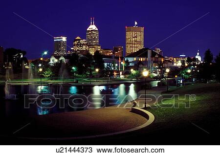Stock Image -  skyline, canal, Indianapolis, park, IN, Indiana, Downtown skyline of Indianapolis from Historic Central Canal in the evening.. Fotosearch