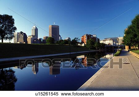 Stock Photography -  skyline, canal, Indianapolis, park, IN, Indiana, Reflection of the downtown skyline of Indianapolis in the calm waters of Historic Central Canal.. Fotosearch