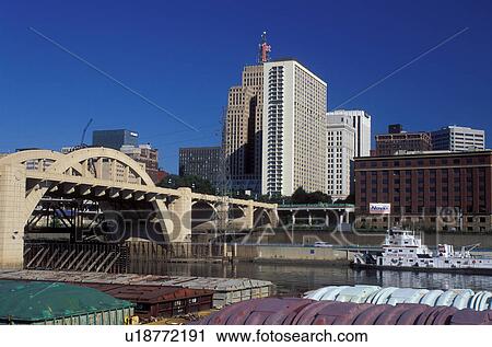 Stock Image -  skyline, St. Paul, MN, Minnesota, Twin Cities, Mississippi River, Downtown skyline of Saint Paul and Robert Street Bridge crossing the Mississippi River. Barges along the river. . Fotosearch