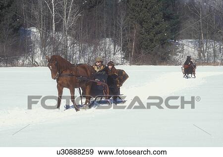 Stock Photo -  sleigh ride, horse and sleigh, Vermont, VT, Couple in one horse open sleigh competing in the Sleigh Rally at Mad River Valley Winter Carnival at Lareau Farm in Waitsfield. . Fotosearch