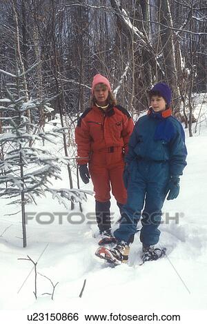 Stock Photograph -  snowshoeing, winter, VT, Vermont, Mother and daughter snowshoe together in the woods in winter.. Fotosearch