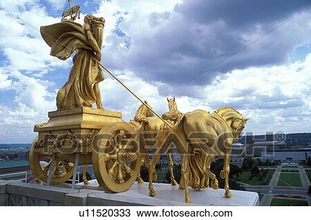 Stock Image -  State Capitol, State House, St. Paul, MN, Minnesota, Twin Cities, The Progress of the State a gilded four horse chariot sculpture adorns the base of the dome of The Minnesota State Capitol Building in the Capital City of Saint Paul. . Fotosearch
