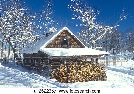 Stock Photo -  sugarhouse, maple syrup, winter, Marshfield, VT, Vermont, Sugar shack with a pile of wood in winter in Marshfield.. Fotosearch