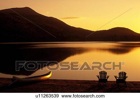 sunrise, lake, Adirondack chairs, Adirondacks, New York, Blue Mountain Lake, NY, A canoe and two Adirondack chairs on the beach at sunrise on Blue Mountain Lake in the Adirondacks. View Large Photo Image Stock Photo - sunrise, lake, Adirondack chairs, Adirondacks, New York, Blue Mountain Lake, NY, A canoe and two Adirondack chairs on the beach at sunrise on Blue Mountain Lake in the Adirondacks.. Fotosearch