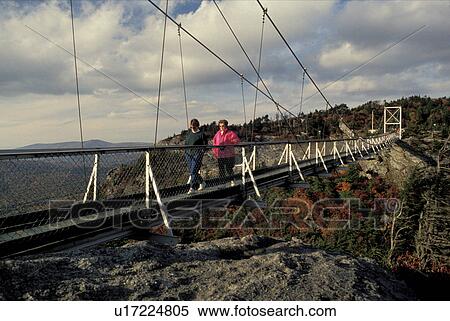 Stock Photography -  suspension bridge, North Carolina, NC, Women walking across Mile High swinging bridge at Grandfather Mountain in the fall.. Fotosearch