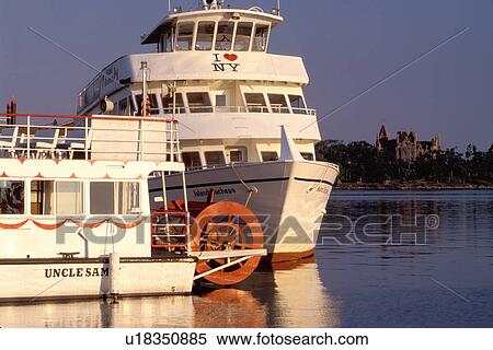 Stock Photography -  Thousand Islands, Alexandria Bay, New York, St. Lawrence River, NY, Uncle Sam Boat Tours on Alexandria Bay along the St. Lawrence River. Boldt Castle in the background.. Fotosearch