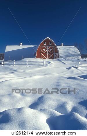 Picture -  Vermont, red barn, farm, VT, Snow-covered red barn with white trim at Diamond Heart Farm in East Albany in the winter.. Fotosearch