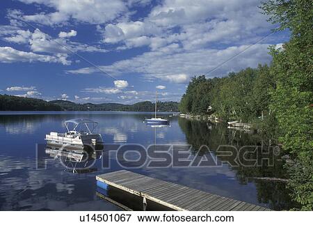 Stock Photo -  Vermont, VT, Boats reflecting in the calm water of Harvey's Lake in Barnet . Fotosearch