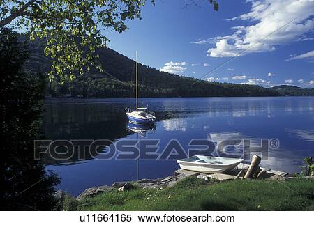 Stock Photography -  Vermont, VT, Boats reflecting in the calm water of Harvey's Lake in Barnet . Fotosearch