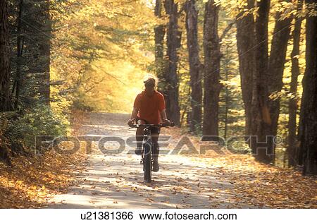 woman, biking, country road, fall, East Montpelier, VT, Vermont, Woman biking on a country road surrounded by colorful fall foliage in East Montpelier in the autumn. View Large Photo Image Stock Photograph - woman, biking, country road, fall, East Montpelier, VT, Vermont, Woman biking on a country road surrounded by colorful fall foliage in East Montpelier in the autumn.. Fotosearch