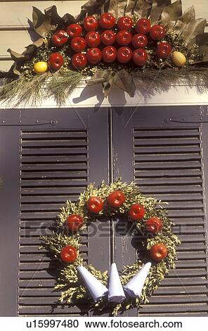 Stock Image -  wreath, Colonial Williamsburg, Virginia, VA, Williamsburg, A wreath made of greens and red apples decorates a door of a home for Christmas in Colonial Williamsburg.. Fotosearch
