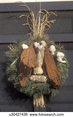 Stock Photo -  wreath, Colonial Williamsburg, Virginia, VA, Williamsburg, A spray made of greens, cotton, dried tobacco leaves, and wheat decorates the iron railing of the village store for Christmas in Colonial Williamsburg.. Fotosearch