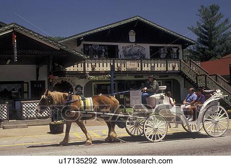 Stock Image -  Alpine Village, carriage ride, Helen, GA, Georgia, Horse-drawn carriage carries visitors through the alpine village of Helen in North Georgia.. Fotosearch
