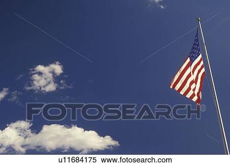 American Flag, sky, clouds, The U. S. flag flies against a blue sky in Atlanta, GA. View Large Photo Image Stock Photography - American Flag, sky, clouds, The U. S. flag flies against a blue sky in Atlanta, GA.. Fotosearch