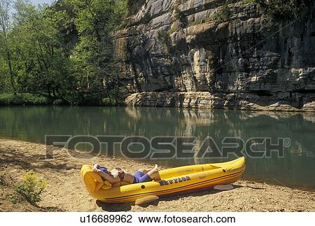 AR, Ozark Mountains, Arkansas, Girl sunbathing in an inflatable yellow canoe on the edge of the scenic Buffalo National River in the Ozark Mountains in Arkansas. View Large Photo Image Stock Image - AR, Ozark Mountains, Arkansas, Girl sunbathing in an inflatable yellow canoe on the edge of the scenic Buffalo National River in the Ozark Mountains in Arkansas.. Fotosearch