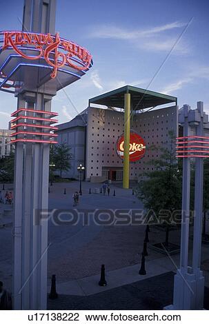 Stock Image -  Atlanta, GA, Georgia, Underground Atlanta, World of Coca-Cola Atlanta illuminated in the evening at Kenny's Alley across from Underground Atlanta in downtown Atlanta.. Fotosearch