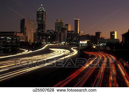 Stock Photo -  Atlanta, GA, skyline, expressway, Georgia, Skyline of downtown Atlanta and streaks of car lights on I-75 and I-85 connector at sunset.. Fotosearch