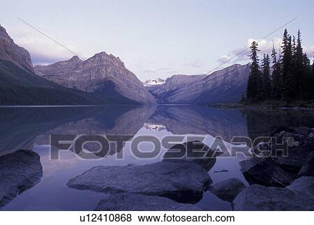 Banff National Park, Canada, Alberta, Canadian Rockies, Reflection of the surrounding mountains in the calm waters of Hector Lake in Banff National Park in Alberta. View Large Photo Image Stock Photo - Banff National Park, Canada, Alberta, Canadian Rockies, Reflection of the surrounding mountains in the calm waters of Hector Lake in Banff National Park in Alberta.. Fotosearch