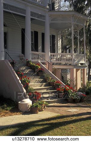 Stock Image -  Beaufort, South Carolina, SC, Red geraniums line the steps of an Historic House in the Historic District in the town of Beaufort in the spring.. Fotosearch