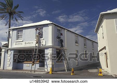 Stock Image -  Bermuda, St. George's Parish, Painting a Wine Shop in St George in Bermuda . Fotosearch